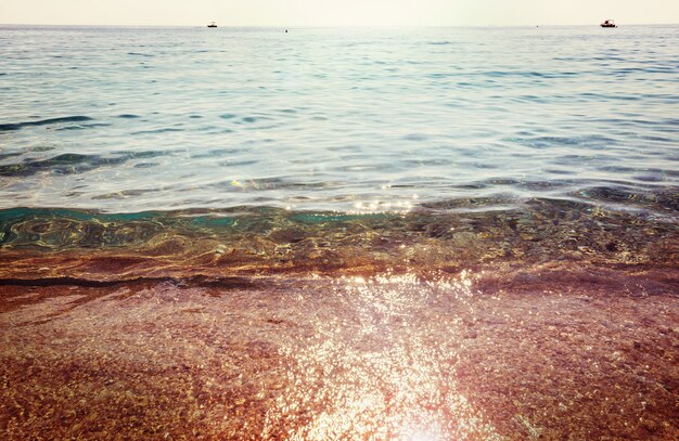 Foto onda blu sulla spiaggia.