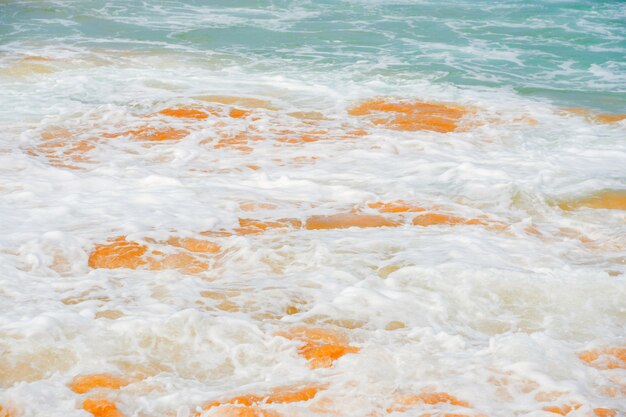 Blue waves of the ocean and yellow sand of the beach.