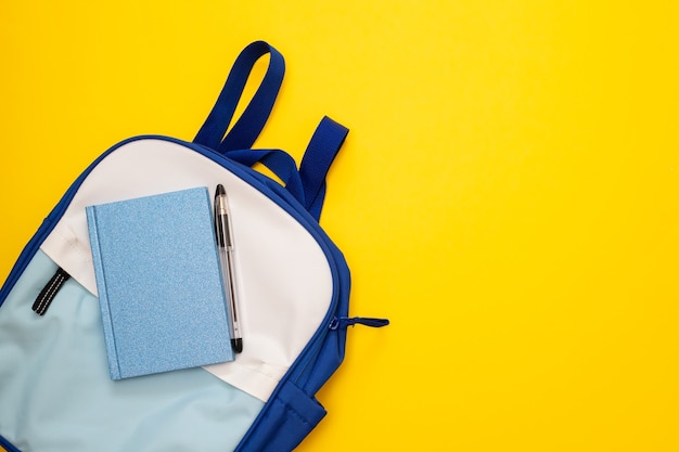 Blue and white backpack on yellow background