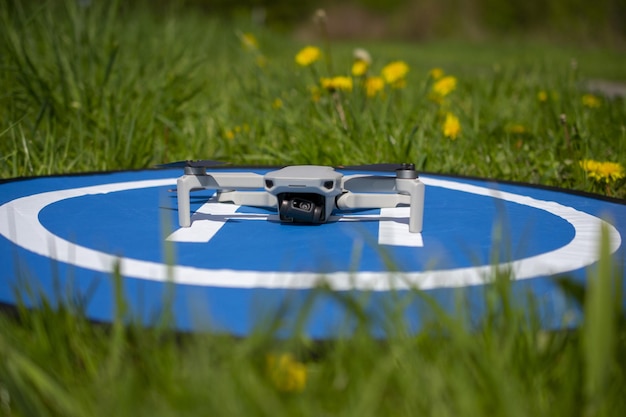 A blue and white drone sits in the grass.