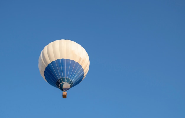 青い空を飛んでいる青と白の熱気球