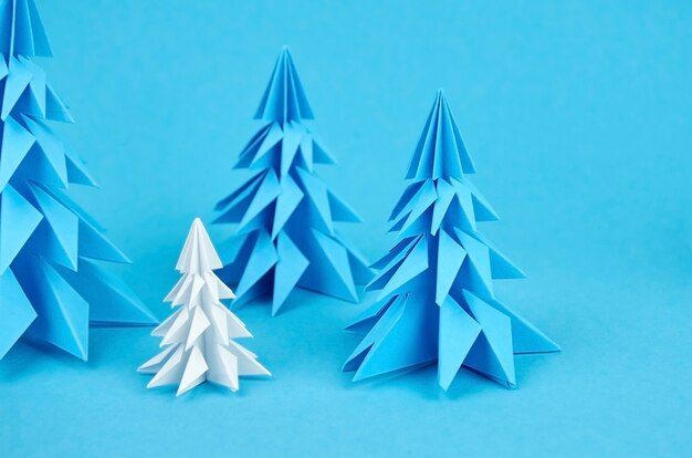 Blue and white paper origami christmas trees composition