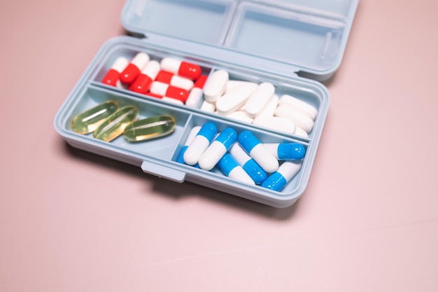 A blue and white pill box with pills inside.