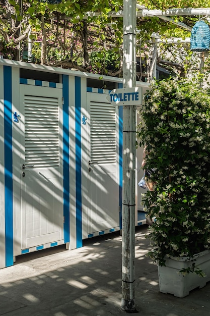 Blue and white striped changing rooms and toilet on the beach