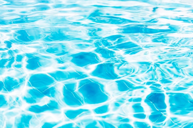 Blue white swimming pool ripped water surface with waves and nice sun sparkles