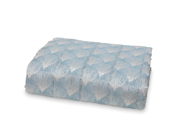 A blue and white throw with a floral pattern.