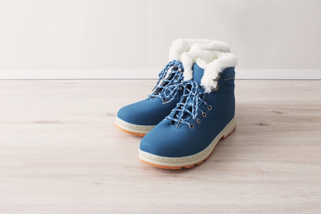 Foto scarpe blu di inverno sul pavimento di legno