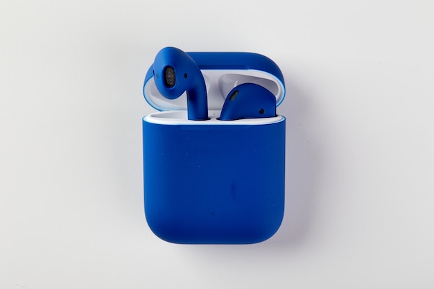 Blue wireless headphones in charging case closeup
