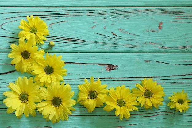 blue wooden background with yellow flowers