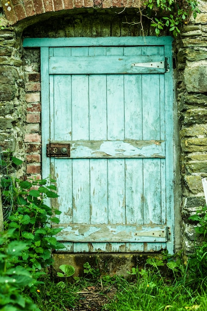 Photo blue wooden door in a stone wall