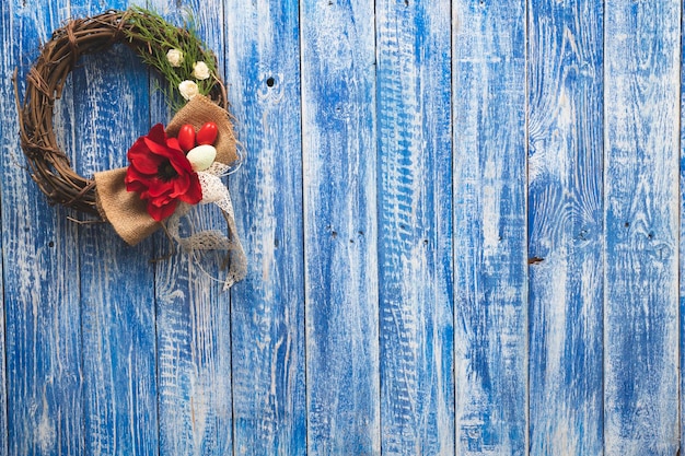 A blue wooden wall with a wreath on it