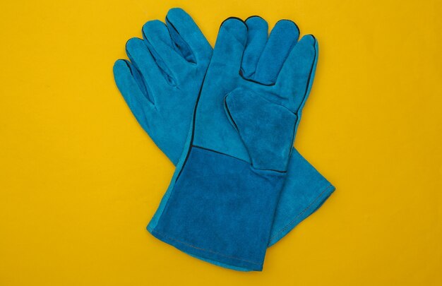 Blue Work gloves on yellow background. Top view