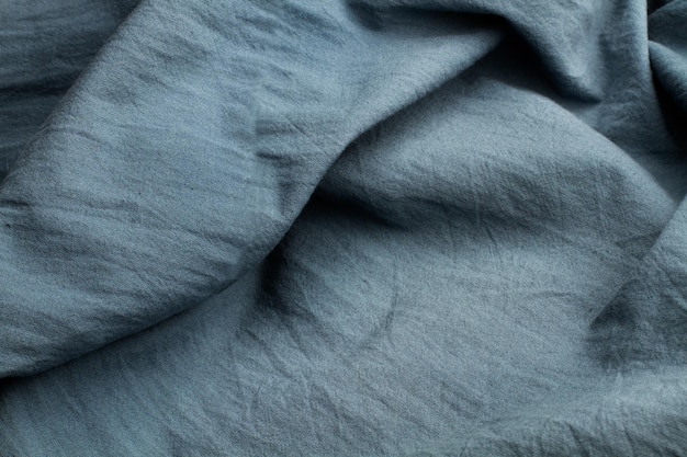 A blue wrinkled fabric background in a close up view