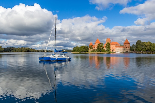 Blue yacht on Galve lake, Lithuania with Trakai castle on background