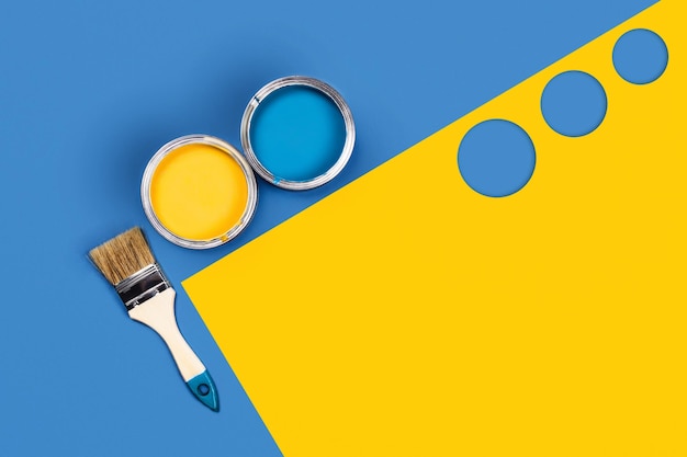 Фото Голубо-желтый фон с двумя банкушками для краски и одной щеткой.