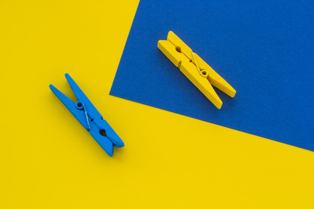 Blue and yellow clothespins on the background, close-up