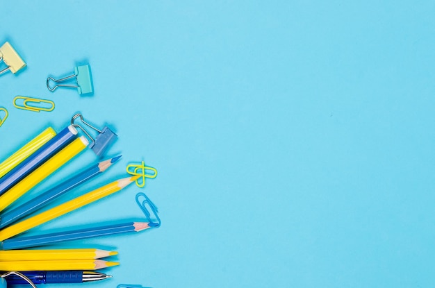 Blue and yellow school stationery on blue background