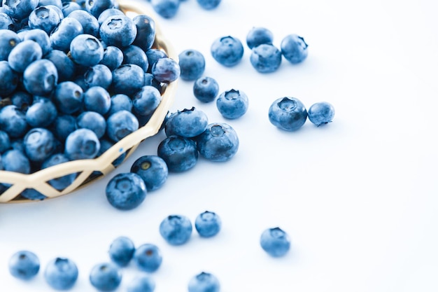 blueberries in bamboo basket on white background
