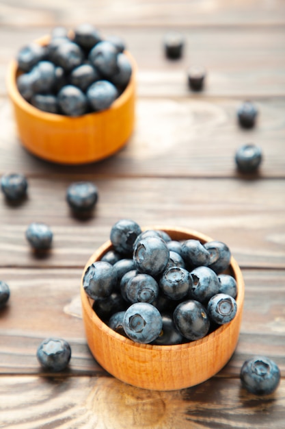 Blueberries in a bowls on brown wooden table