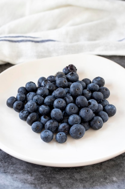 Blueberries on a dark background Fresh blueberries on the plate close up