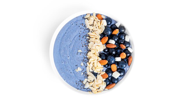 Blueberries dessert with fruits, almond and chia seeds isolated on a white background. Blue smoothie bowl with berries. High quality photo