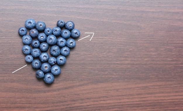 Blueberries laid out on a wooden board in the form of a heart