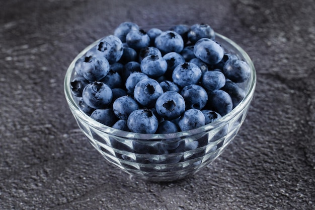 Blueberries organic natural berry on dark background Blueberry in glass bowl plate