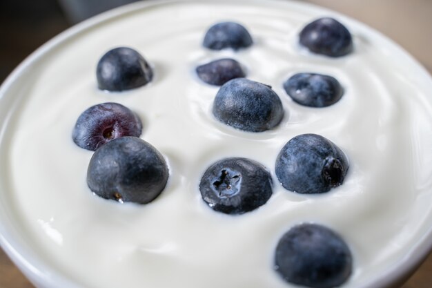 Blueberries in organic yogurt, close up photo