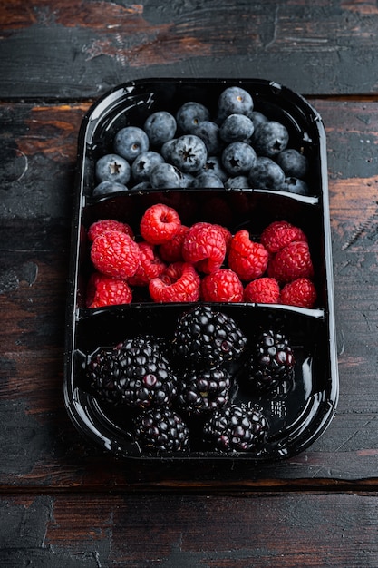Blueberries, raspberries with blackberries in a container