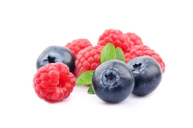 Blueberries and raspberry with leaves isolated on white