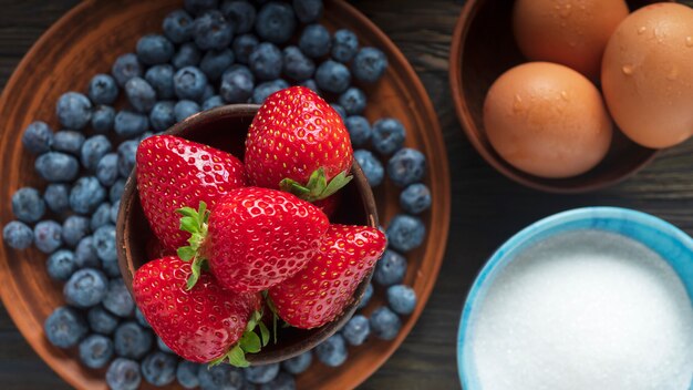 Blueberries, strawberries, eggs and sugar. Top view.