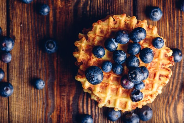 Blueberries on the Top of the Waffle and Other Scattered on Wooden Background Copy Space on the Left