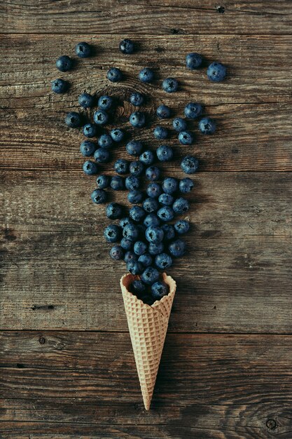 Blueberries in waffle cone on wooden table