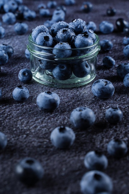 Blueberries with water drops on black background Blueberry in glass bowl plate