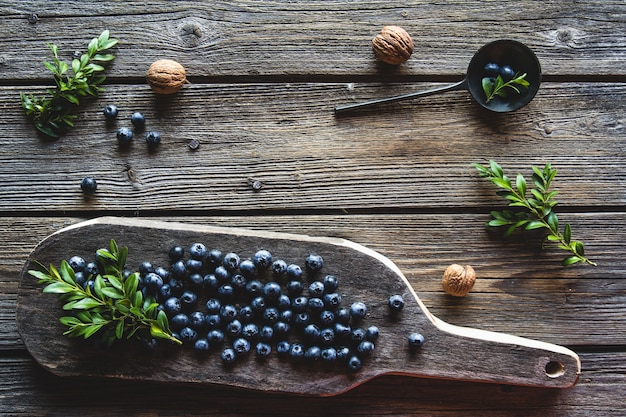 Blueberries on a wood board, wooden background closeup.