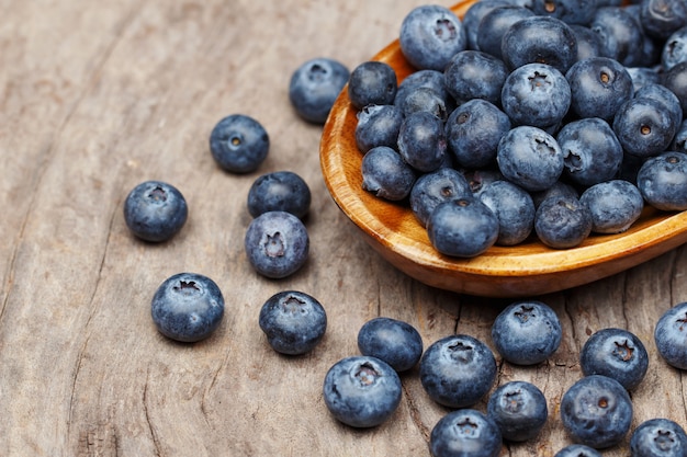 Blueberries in a wood bowl on a wooden table, Healthy eating and nutrition concept