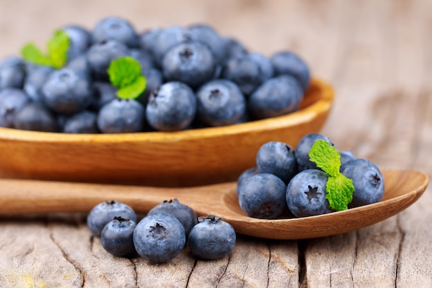 Blueberries in a wood bowl on a wooden table