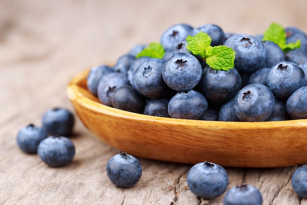 Blueberries in a wood bowl on a wooden table