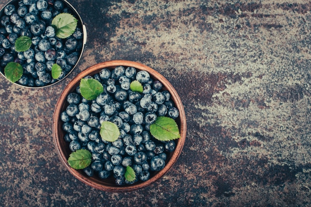 Blueberries in wood dishes on dark background