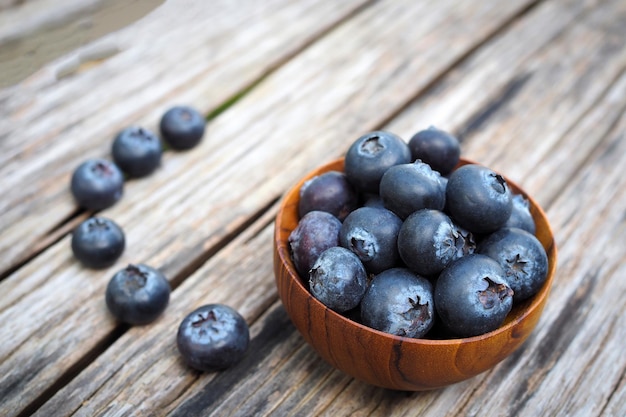 Blueberries in wooden bowls on old wooden table background Rustic style