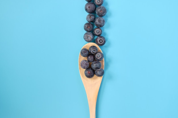 Blueberries on a wooden spatula.