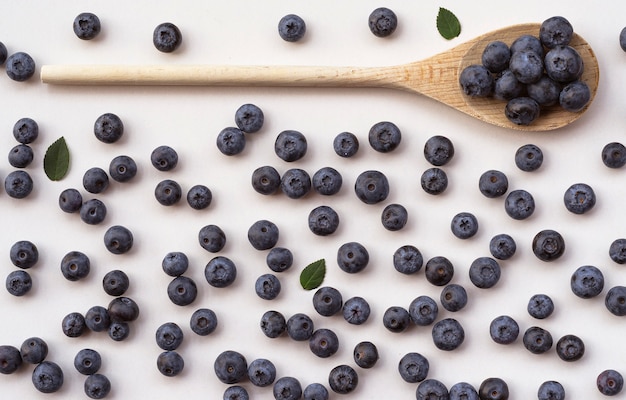 Blueberries in a wooden spoon on white