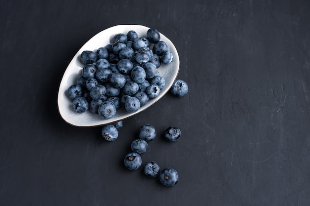 Blueberry antioxidant organische superfood in keramische kom voor gezond eten en dieetvoeding Bovenaanzicht op donker zwart