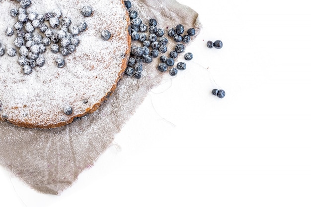 Photo blueberry cake with fresh bluberries and sugar powder on a beige fabric