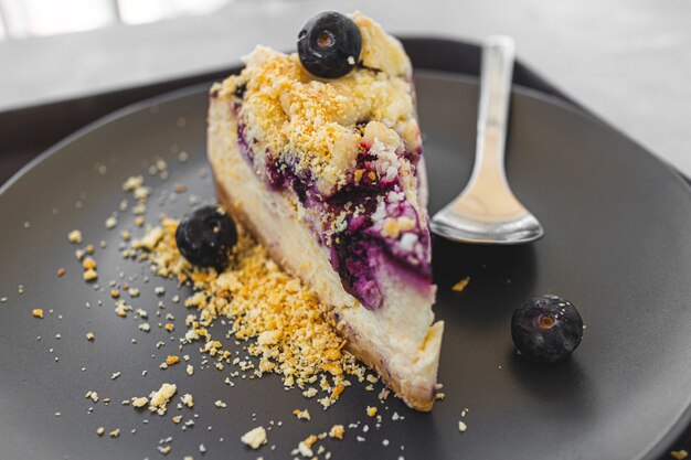 Blueberry cheese cake on dark plate in the cafe