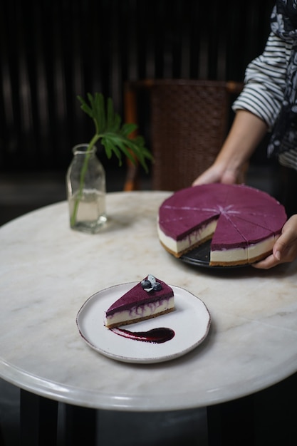 Blueberry cheesecake purple blueberry radijs sauce plaats op een rond wit bord. de eigenaar van de bakkerij die op een ronde steen serveerde.