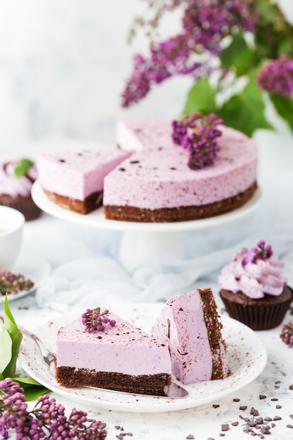 チョコレートビスケットとブルーベリーのチーズケーキ装飾ライラック色の花