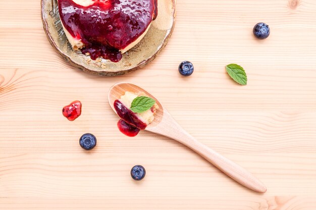 Blueberry cheesecake with fresh mint leaves on wooden background.