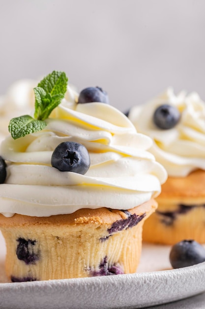 Blueberry cupcakes decorated with vanilla cream