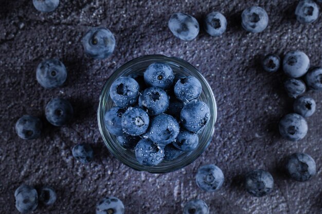 Blueberry in glass plate top view Blueberries organic natural berry with water drops on dark background